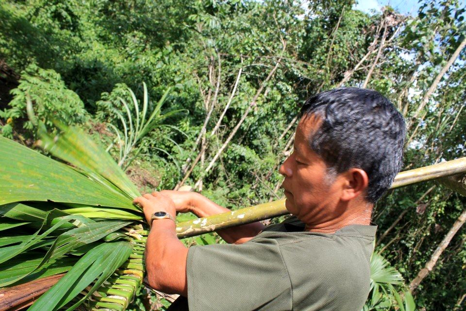Eduardo Senior weaving palm leaves.